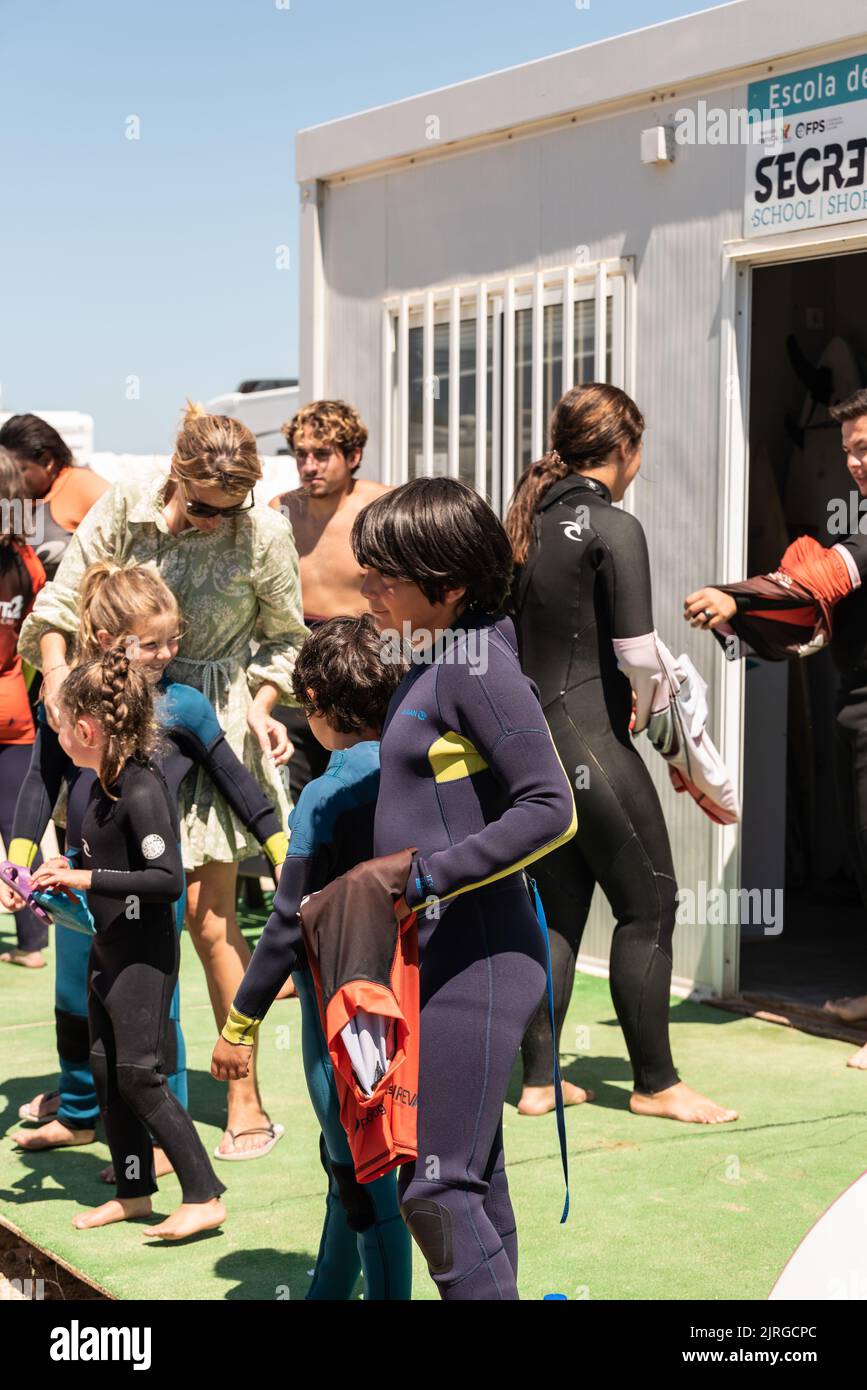 Aveiro, Portugal August 19, 2022 people with wetsuits and pick up surfboards at the secreto