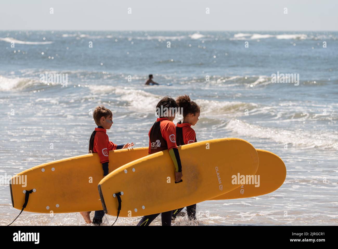 Aveiro, Portugal - August 19, 2022: A group of surfing students walk with their instructor to receive their lessons. Stock Photo
