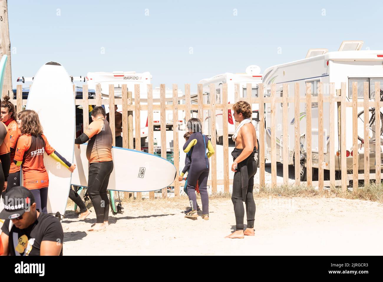 Aveiro, Portugal - August 19, 2022: people with wetsuits and pick up surfboards at the secreto surf school facilities. Stock Photo