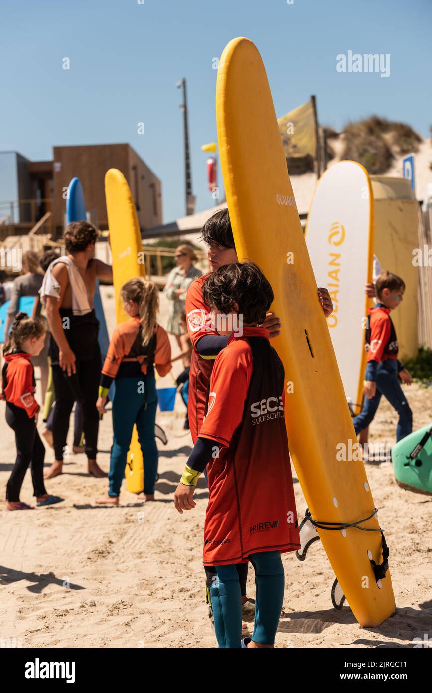 Aveiro, Portugal August 19, 2022 people with wetsuits and pick up surfboards at the secreto