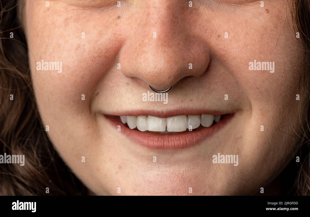 Close up of young woman with pierced nose smiling. Stock Photo