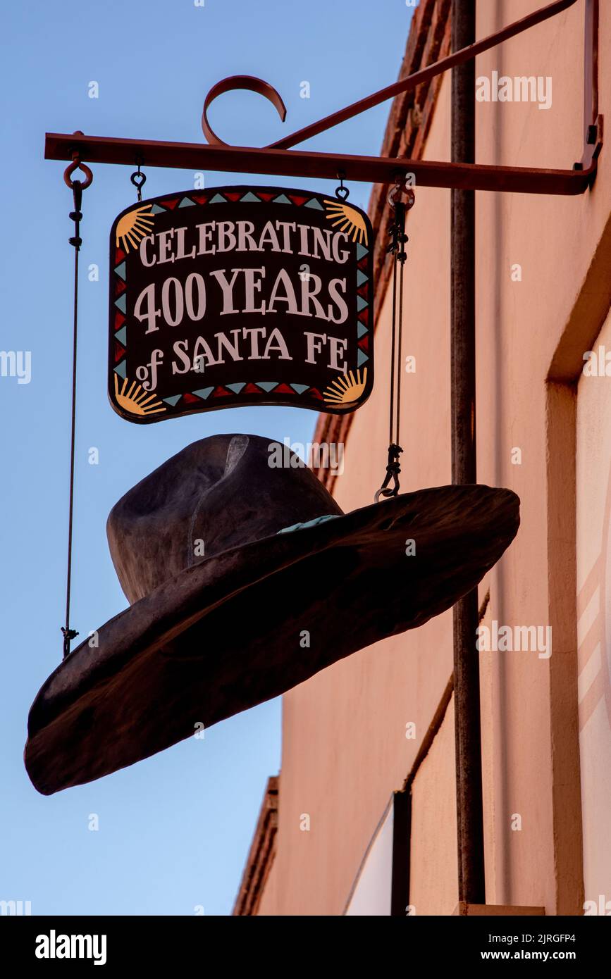 Sign with oversized cowboy hat hanging from the wall ofThe Santa Fe Hat Company. Stock Photo
