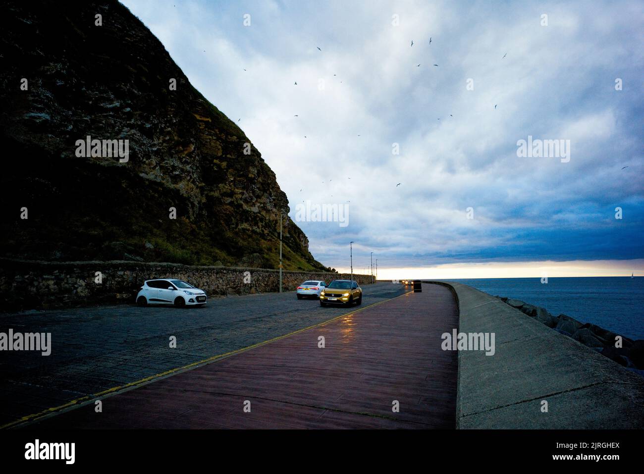 Marine Drive in Scarborough at dusk with nesting birds in the cliffs above Stock Photo