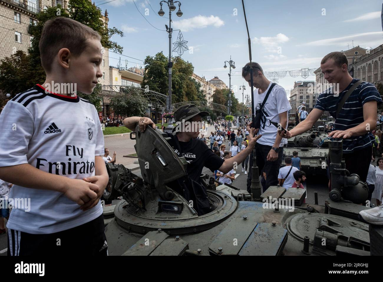 Kyiv, Kyiv Oblast, Ukraine. 21st Aug, 2022. Teenagers climb inside a destroyed Russian military tank showcased on the streets of Kyiv. As dedicated to the upcoming Independence Day of Ukraine, and nearly 6 months after the full-scale invasion of Ukraine on February 24, the country's capital Kyiv holds an exhibition on the main street of Khreschaytk Street showing multiple destroyed military equipment, tanks and weapons from The Armed Forces of The Russian Federation (AFRF).As the Russian full invasion of Ukraine started on February 24, the war that has killed numerous civilians and soldiers, Stock Photo