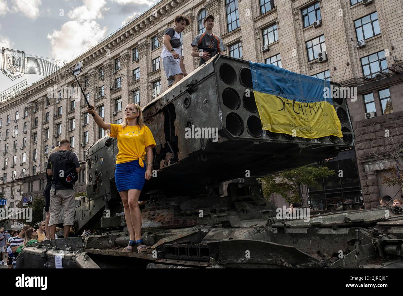 August 21, 2022, Kyiv, Kyiv Oblast, Ukraine: A woman takes a selfie as the people climb on the display of a destroyed Russian Multi Rocket Launch System Vehicle (MLRS) on the streets of Kyiv. As dedicated to the upcoming Independence Day of Ukraine, and nearly 6 months after the full-scale invasion of Ukraine on February 24, the country's capital Kyiv holds an exhibition on the main street of Khreschaytk Street showing multiple destroyed military equipment, tanks and weapons from The Armed Forces of The Russian Federation (AFRF)..As the Russian full invasion of Ukraine started on February 24, Stock Photo