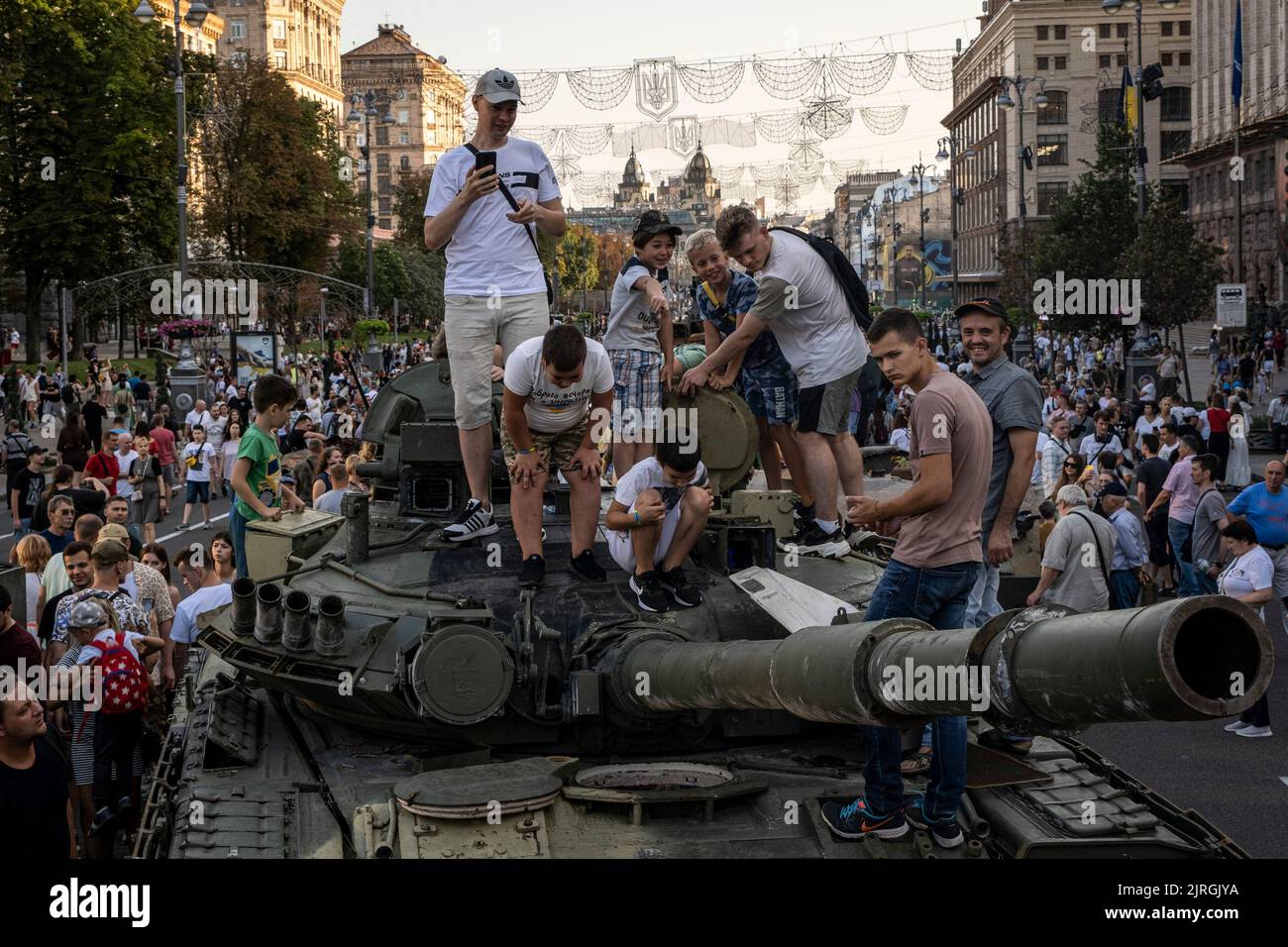 Kyiv, Kyiv Oblast, Ukraine. 21st Aug, 2022. Teenagers and children climb up to the top of a wreckage of a Russian tank as people flocked to see the display of destroyed Russian tanks on the streets of Kyiv. As dedicated to the upcoming Independence Day of Ukraine, and nearly 6 months after the full-scale invasion of Ukraine on February 24, the country's capital Kyiv holds an exhibition on the main street of Khreschaytk Street showing multiple destroyed military equipment, tanks and weapons from The Armed Forces of The Russian Federation (AFRF).As the Russian full invasion of Ukraine started Stock Photo