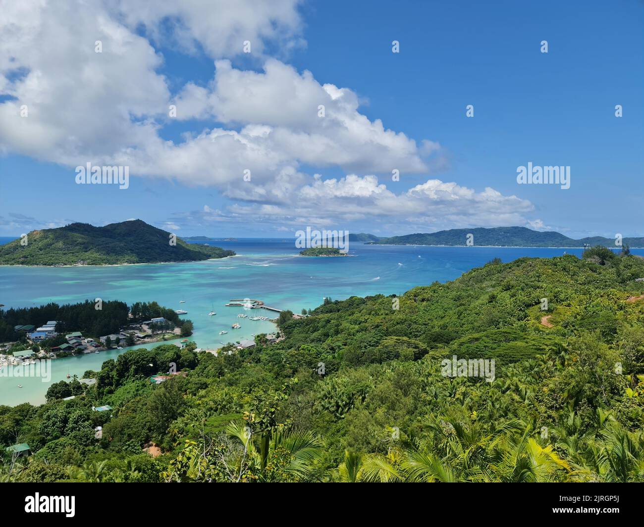 A sunny day on the beach with a cloudy blue sky Stock Photo - Alamy