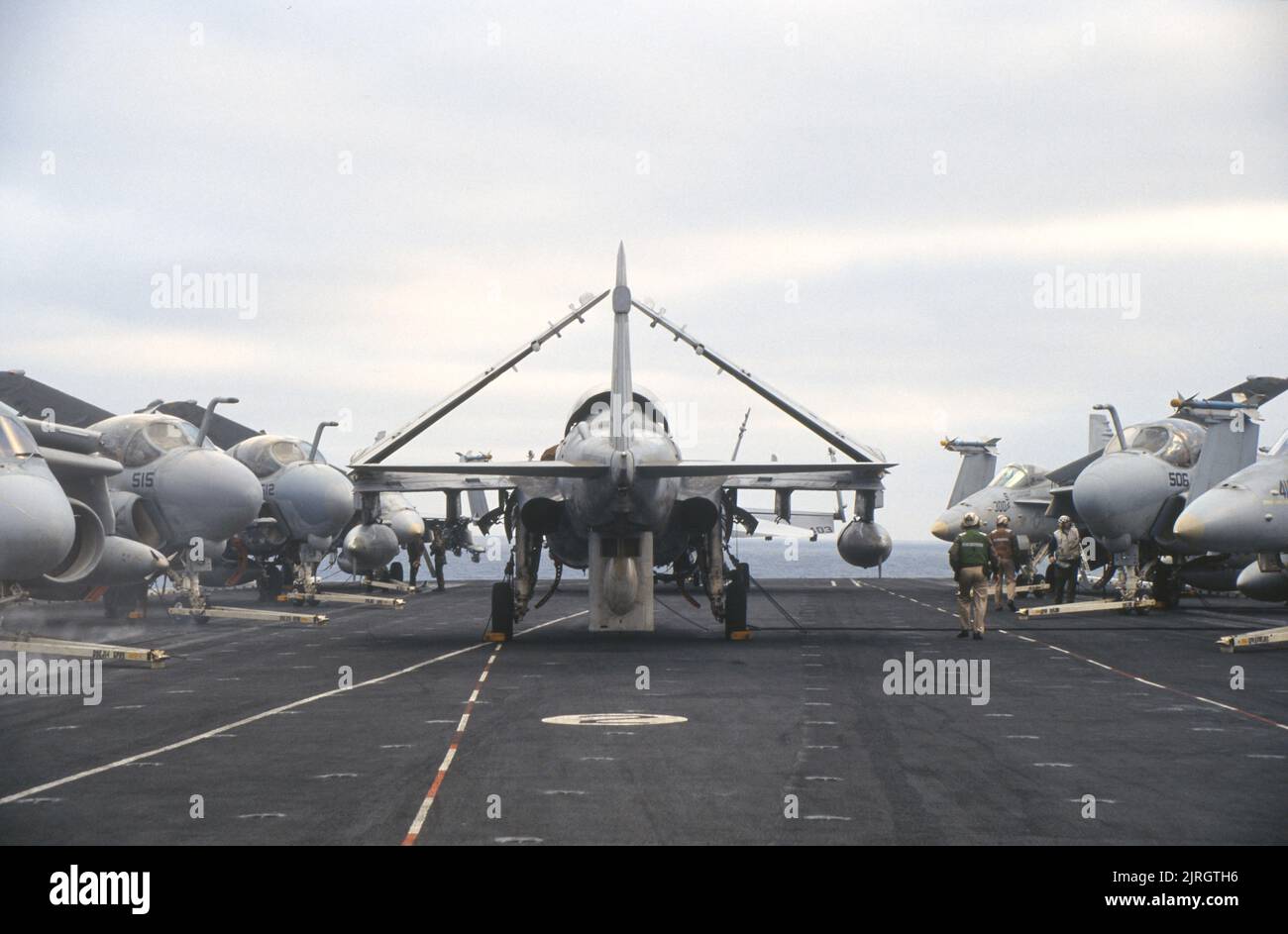 Grumman A-6 Intruders tied down on the bow of an aircraft carrier underway at sea Stock Photo