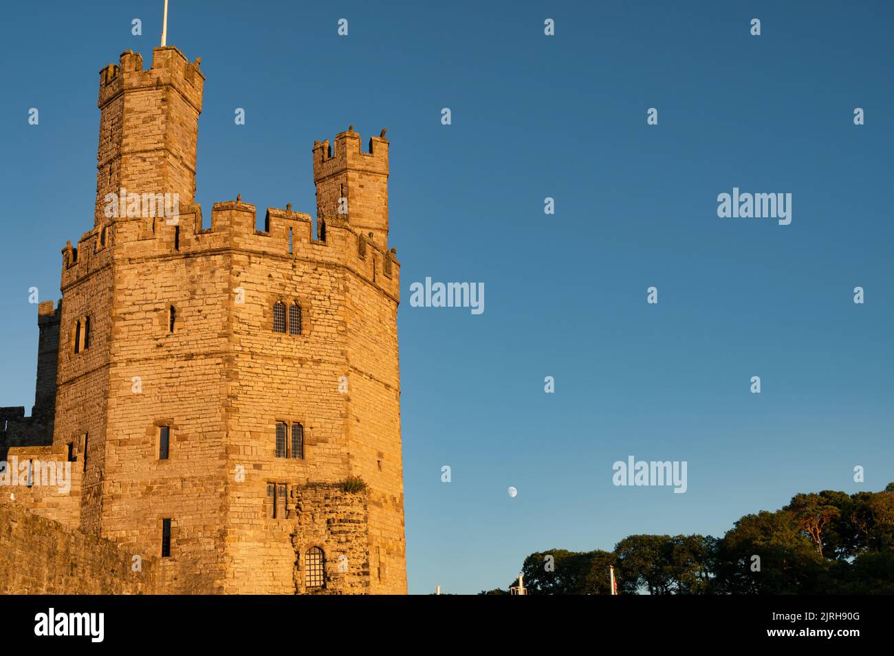 Caernarfon, UK- July 10, 2022: Warm glow of the suset light on  Eagle Tower of Caernarfon Castle in North Wales Stock Photo