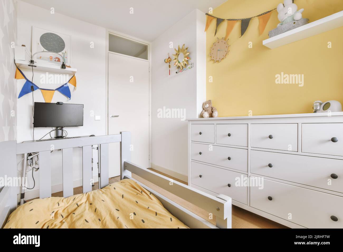 Interior of white room with baby crib near window in daylight Stock