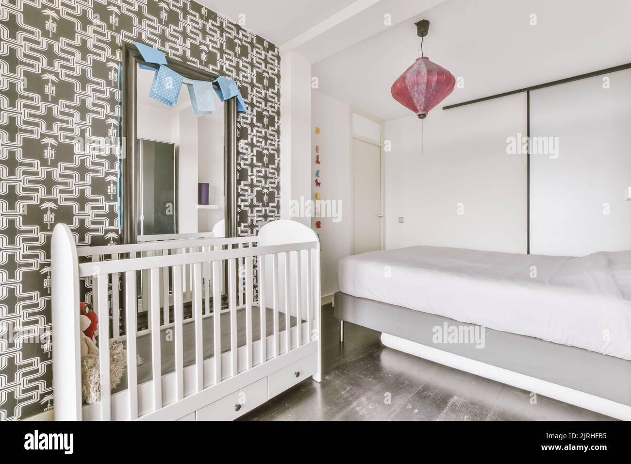 Interior of white room with baby crib near window in daylight Stock