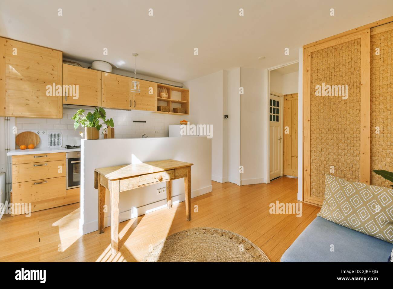 Studio apartment with white walls and open plan kitchen with sofa in