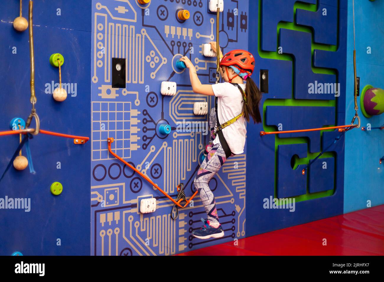 Little girl ascending in rock climbing gym Stock Photo Alamy