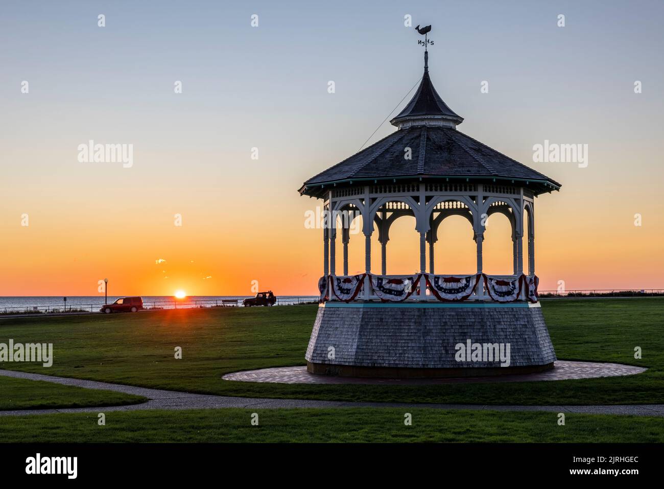 The sun rises behind the Ocean Park gazebo (bandstand) on a clear morning in Oak Bluffs, Massachusetts on Martha's Vineyard. Stock Photo