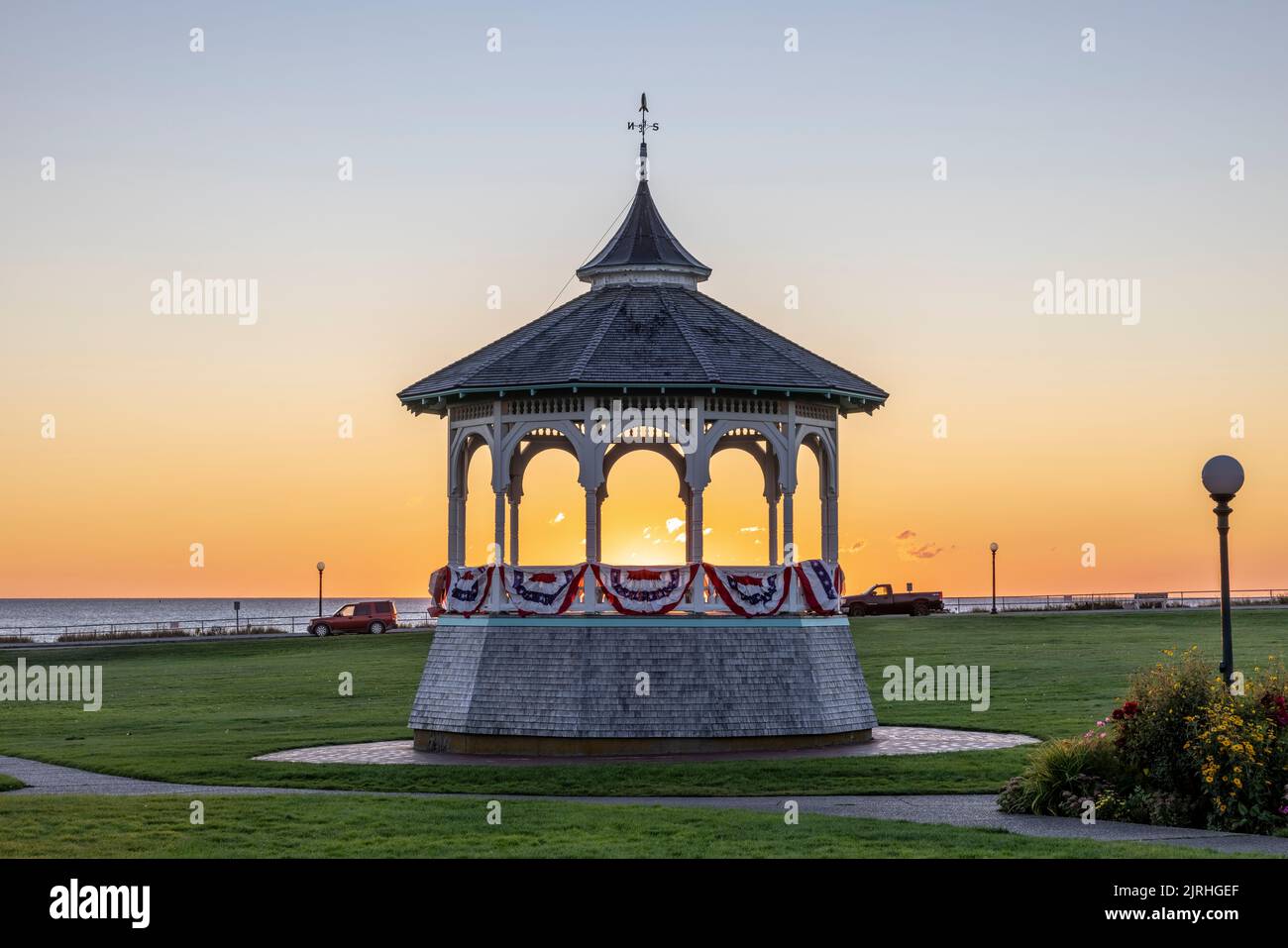 The sun rises behind the Ocean Park gazebo (bandstand) on a clear morning in Oak Bluffs, Massachusetts on Martha's Vineyard. Stock Photo