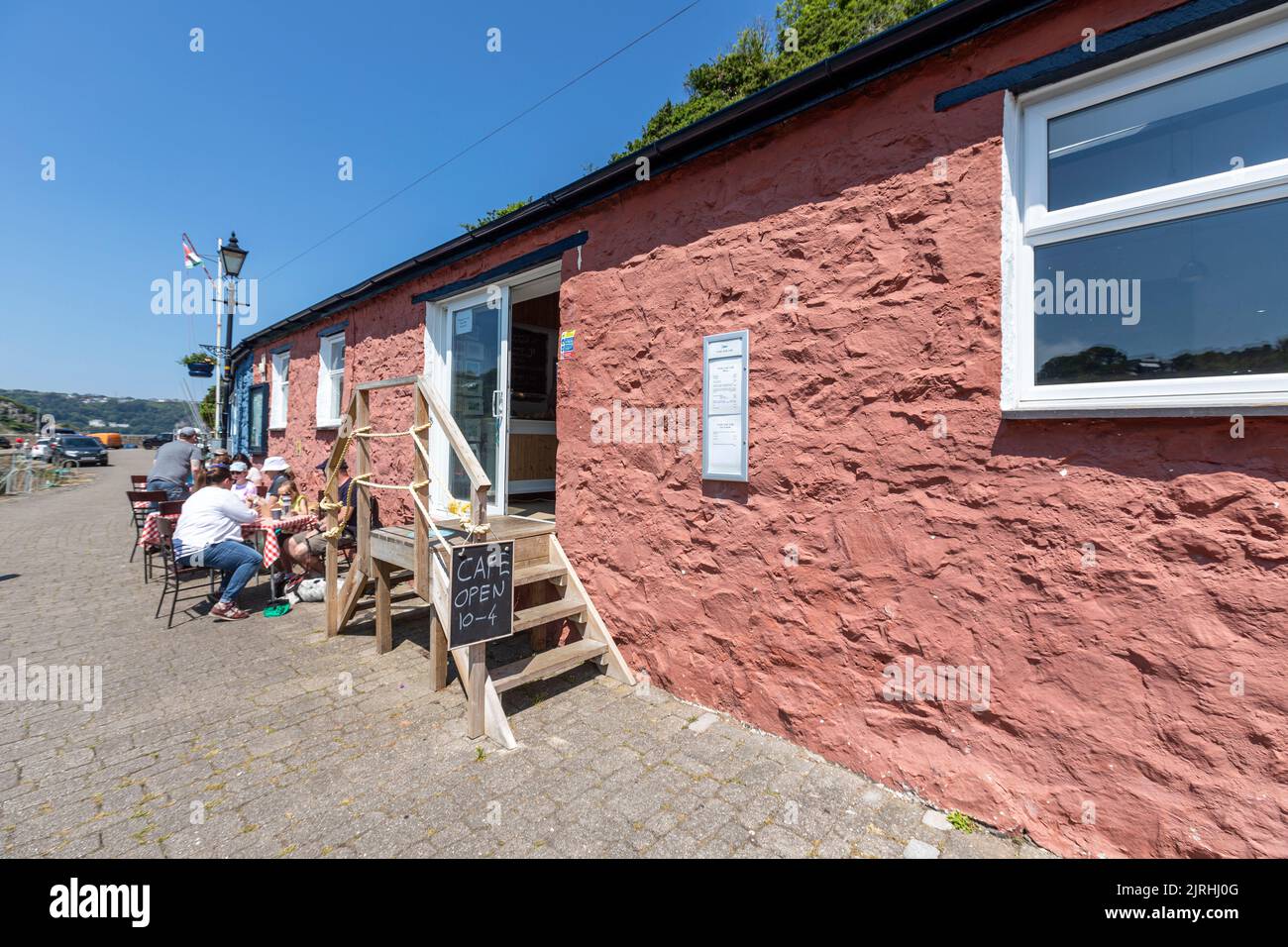 People eating outside the Cafe on the Quay, Village of Fishguard, Pembrokeshire, Wales, UK Stock Photo