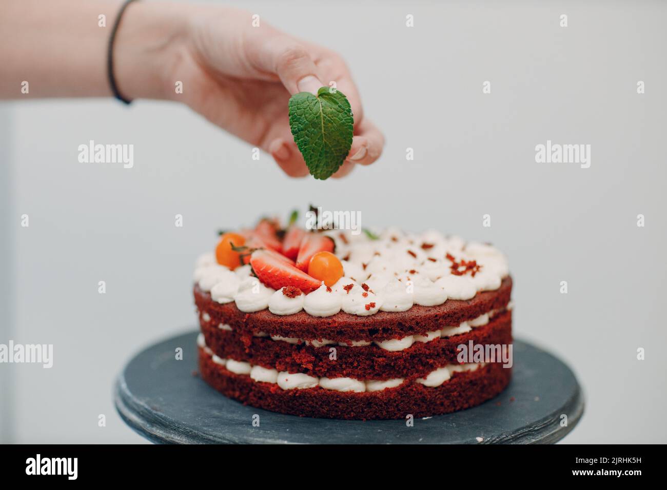 Pastry chef makes delicious red velvet cake. Cooking and decorating