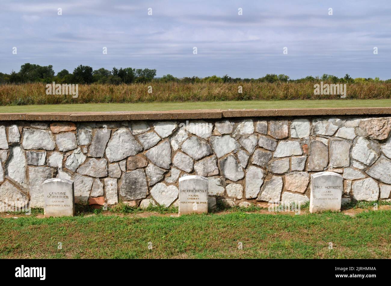 Graves of German soldiers taken prisoner during the Second World War line a stone wall in the historic cemetery at Fort Reno in Oklahoma. Stock Photo