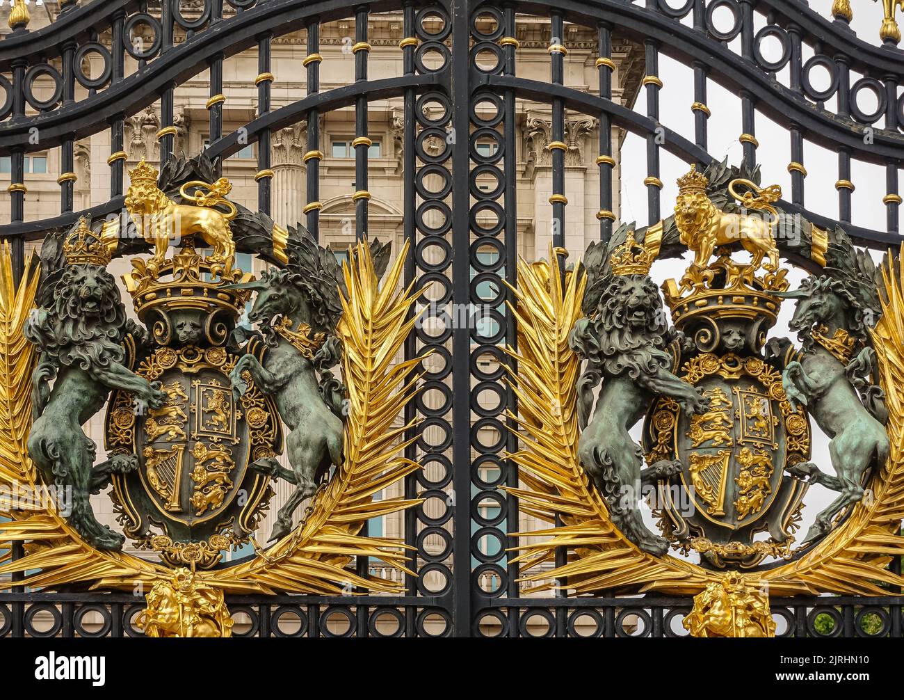 London, England, UK - July 6, 2022: Buckingham Palace. Closeup of double golden royal coat of arms fixed to black metal main gate. Stock Photo