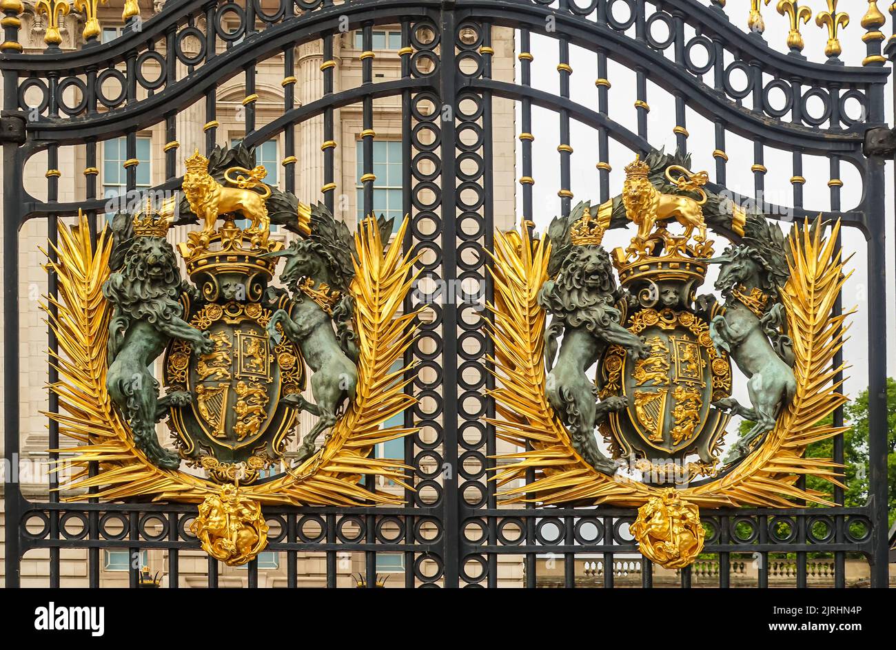 London, England, UK - July 6, 2022: Buckingham Palace. Closeup of two identical golden royal coat of arms fixed to black metal main gate. Stock Photo