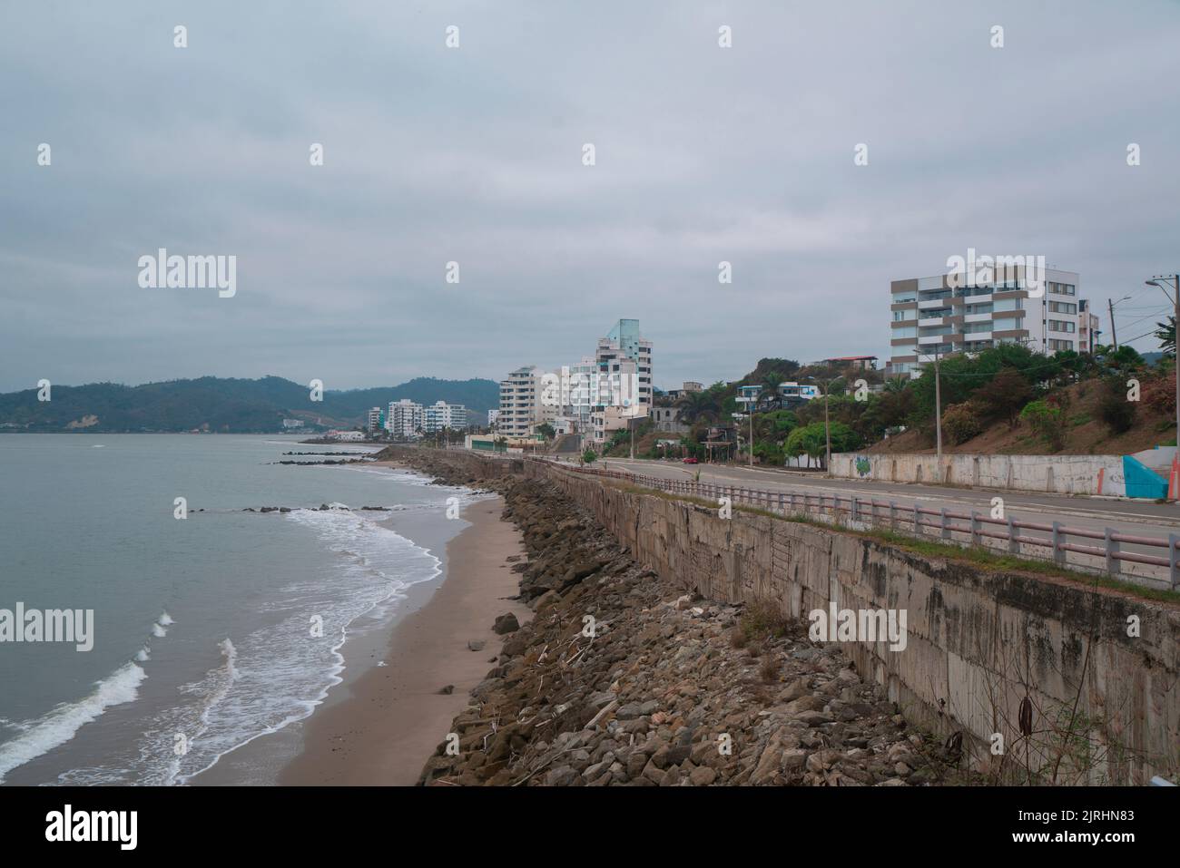 Bahia de Caraquez, Manabi / Ecuador - August 21 2022: Vehicles traveling on the avenue that borders the beach with a panoramic view of the city on a c Stock Photo