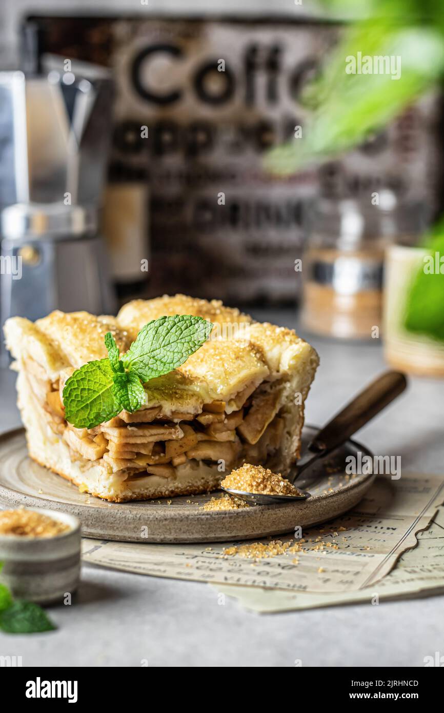 Piece of traditional apple pie with mint leave on ceramic plate, cozy rustic still life, fall baking concept Stock Photo