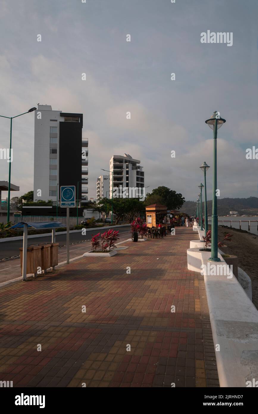 Bahia de Caraquez, Manabi / Ecuador - August 20 2022: People walking on the boardwalk of the city next to the beach on a cloudy day Stock Photo