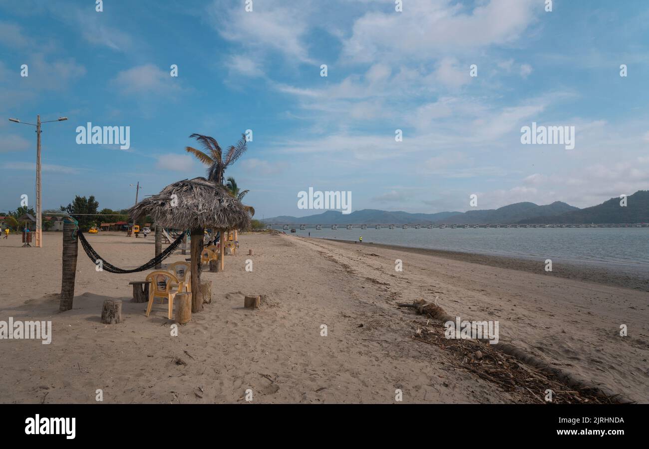 San Vicente, Manabi / Ecuador - August 20 2022: People walking along the beach of the town with the bridge over the Chone river that connects San Vice Stock Photo