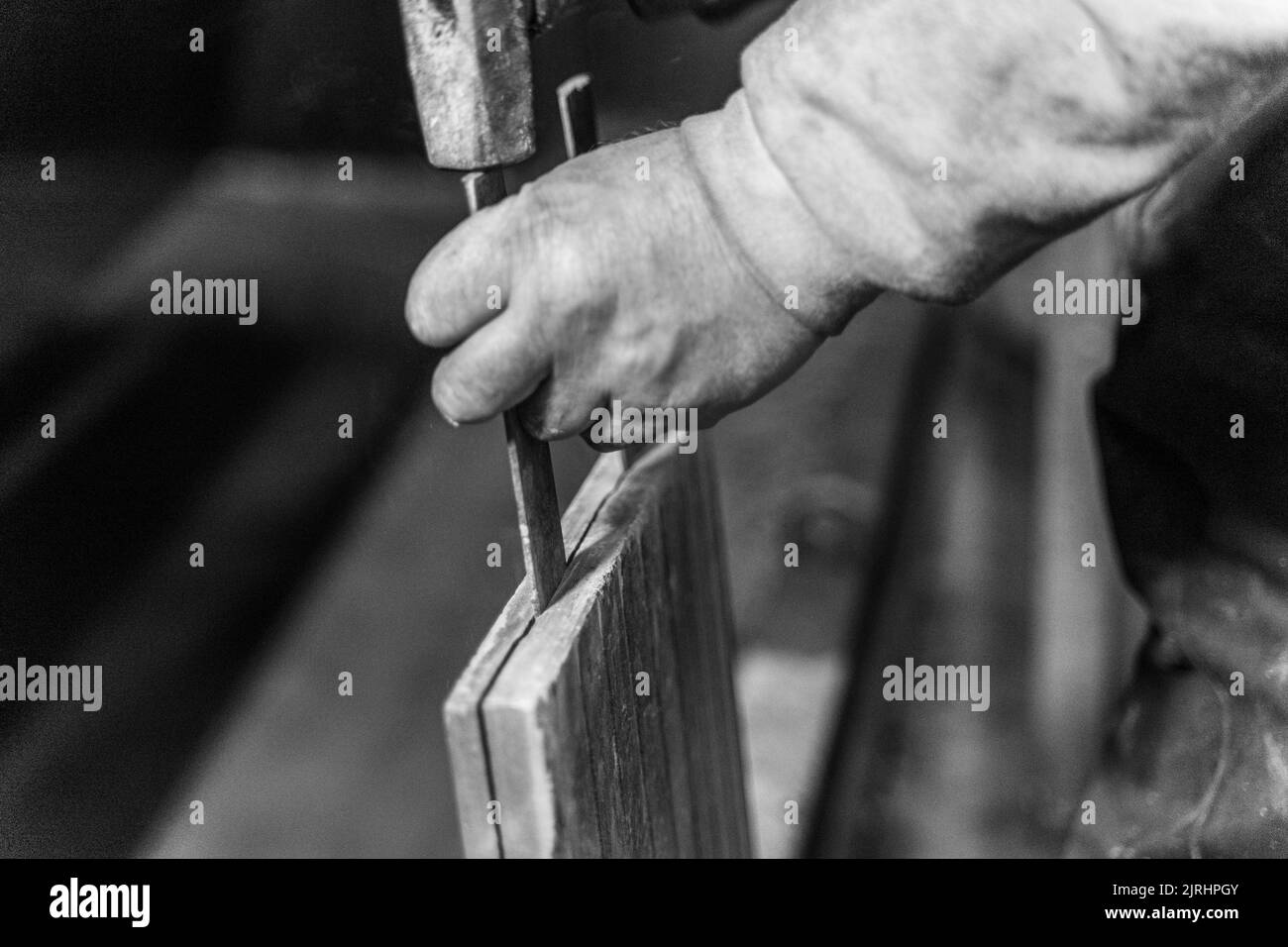 A grayscale of a male hand working in the workshop Stock Photo