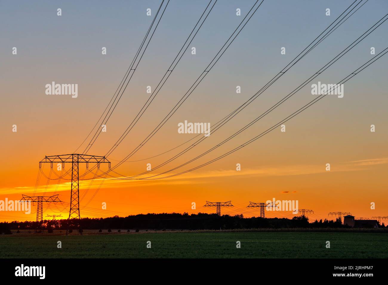 Freileitungstrasse im Sonnenuntergang Übertragung Energie Stock Photo