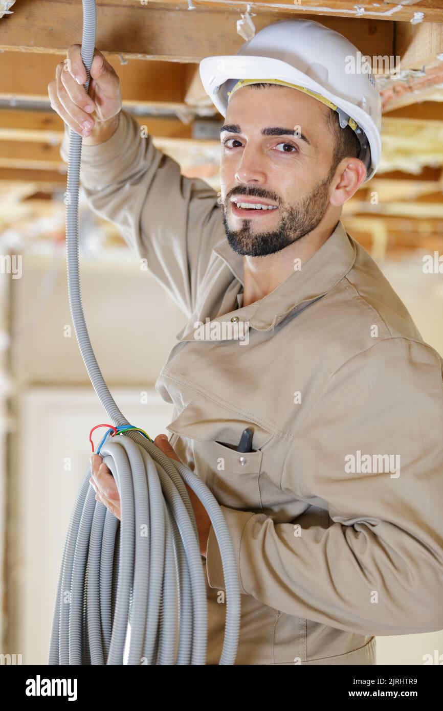 portrait of tradesman holding reel of cable Stock Photo