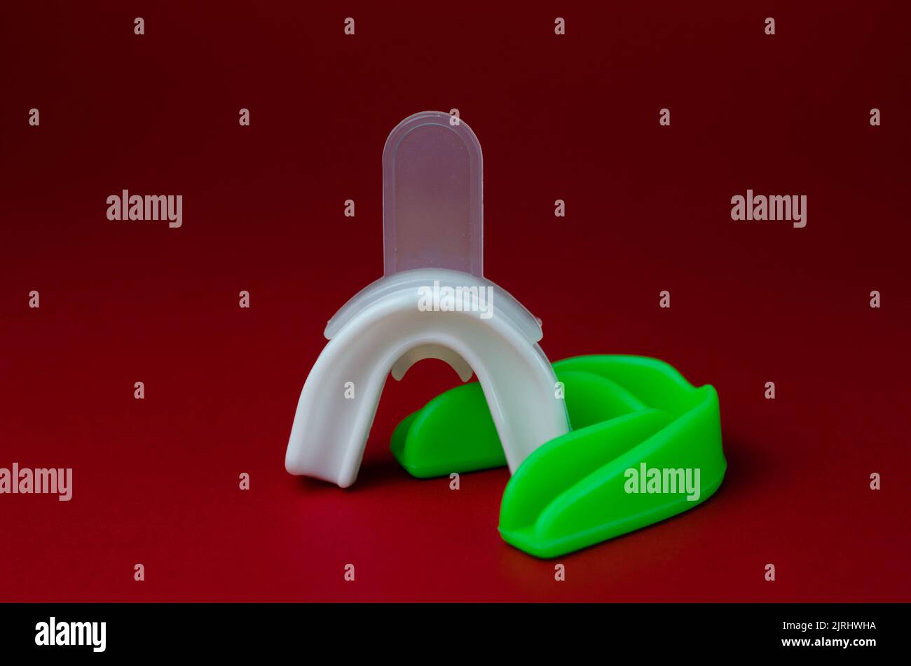 two rubber boxing mouth guards, white and green, protection for lips