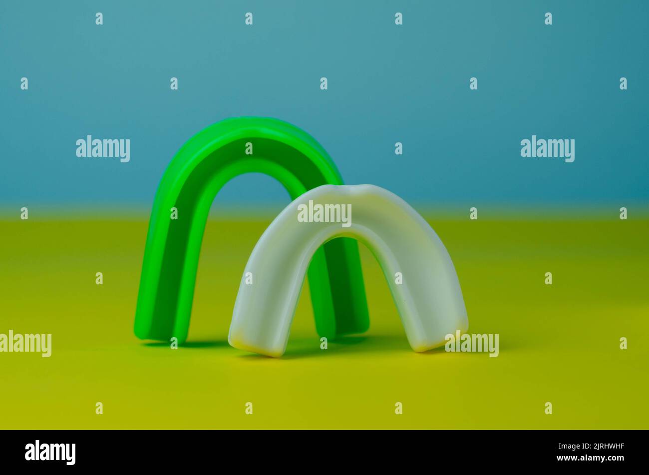 two rubber boxing mouth guards, white and green, protection for lips