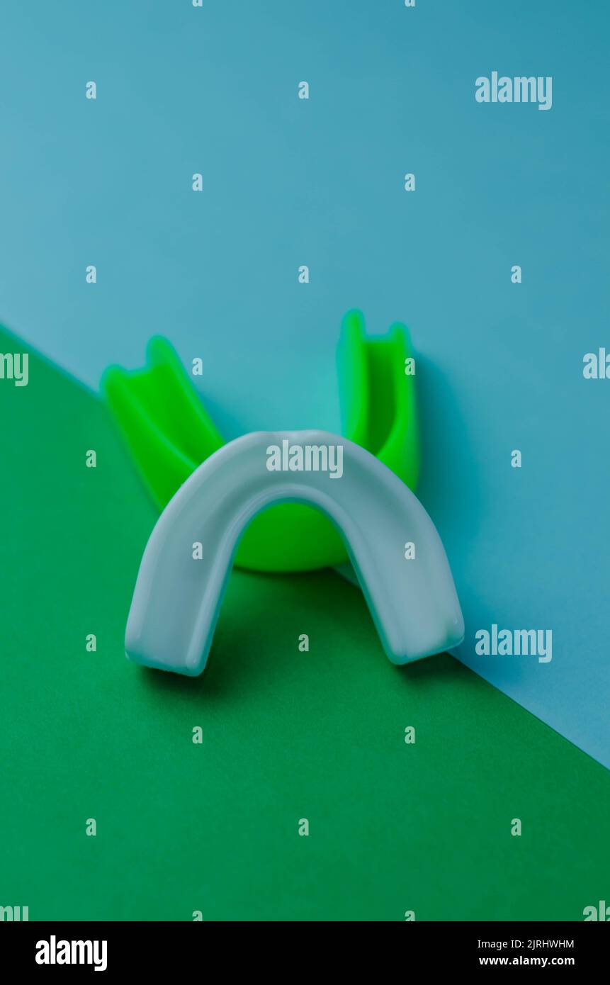 two rubber boxing mouth guards, white and green, protection for lips