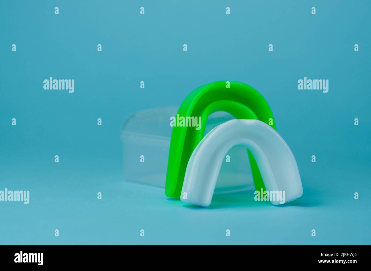 two rubber boxing mouth guards, white and green, protection for lips