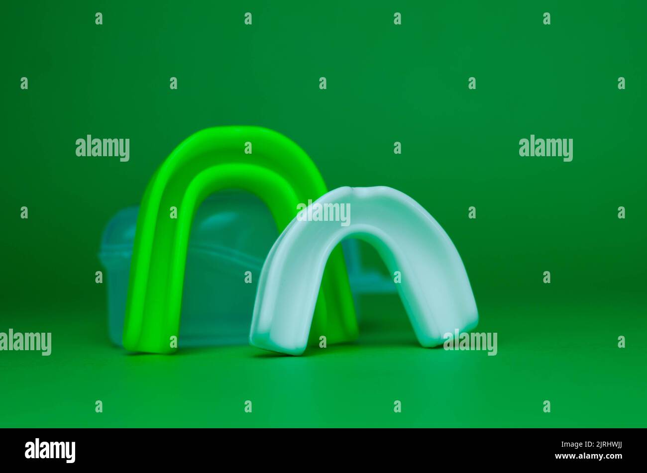 two rubber boxing mouth guards, white and green, protection for lips