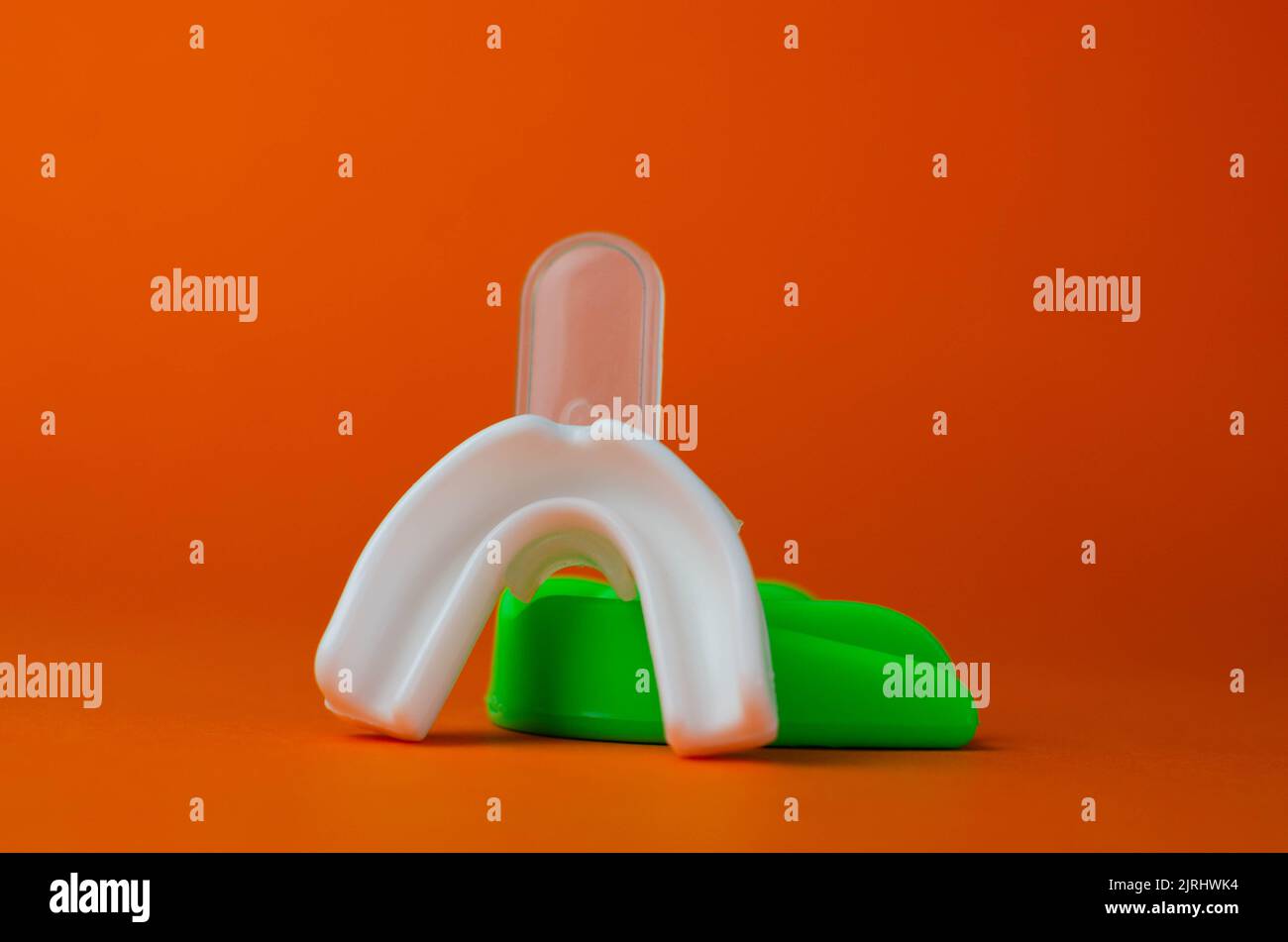 two rubber boxing mouth guards, white and green, protection for lips