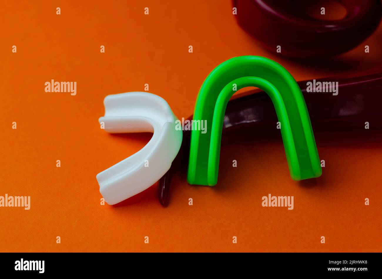 two rubber boxing mouth guards, white and green, protection for lips