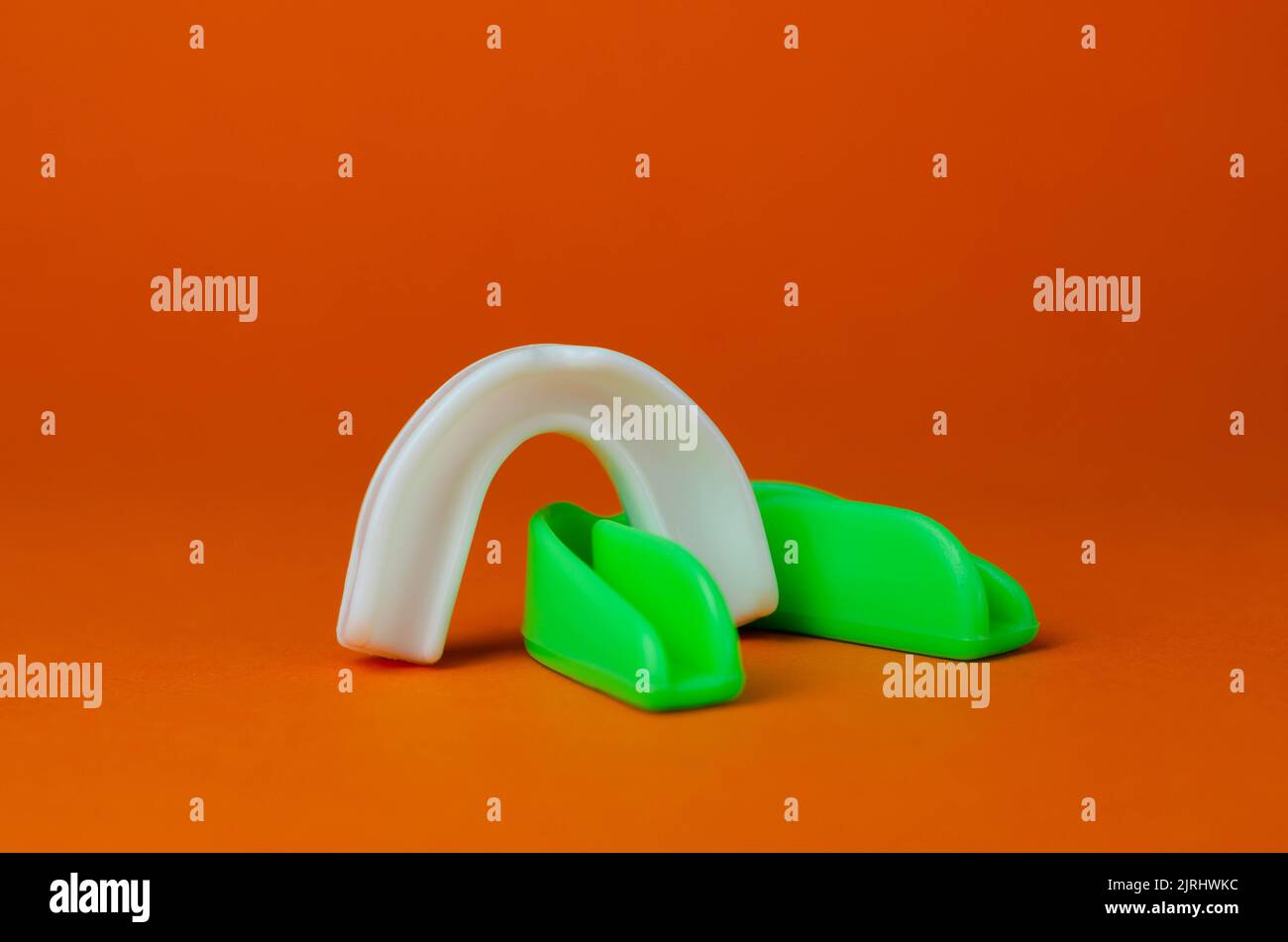 two rubber boxing mouth guards, white and green, protection for lips