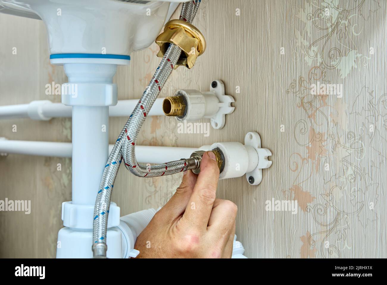 Attached faucet to water supply using braided connecting hose Stock