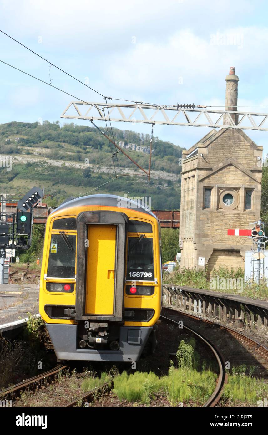 Northern trains express sprinter dmu train leaving Carnforth station 24th August 2022, feather signal at end of platform with weeds in track-bed. Stock Photo