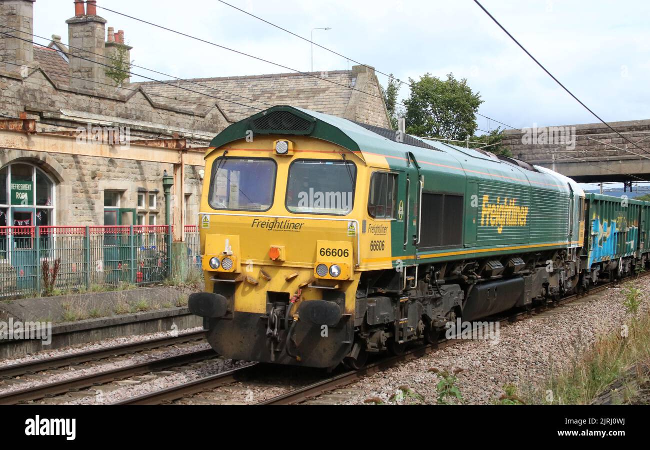 Freightliner class 66, 66606, passing through Carnforth on the West Coast Main Line 24th August 2022 with freight train, wagons with graffiti. Stock Photo