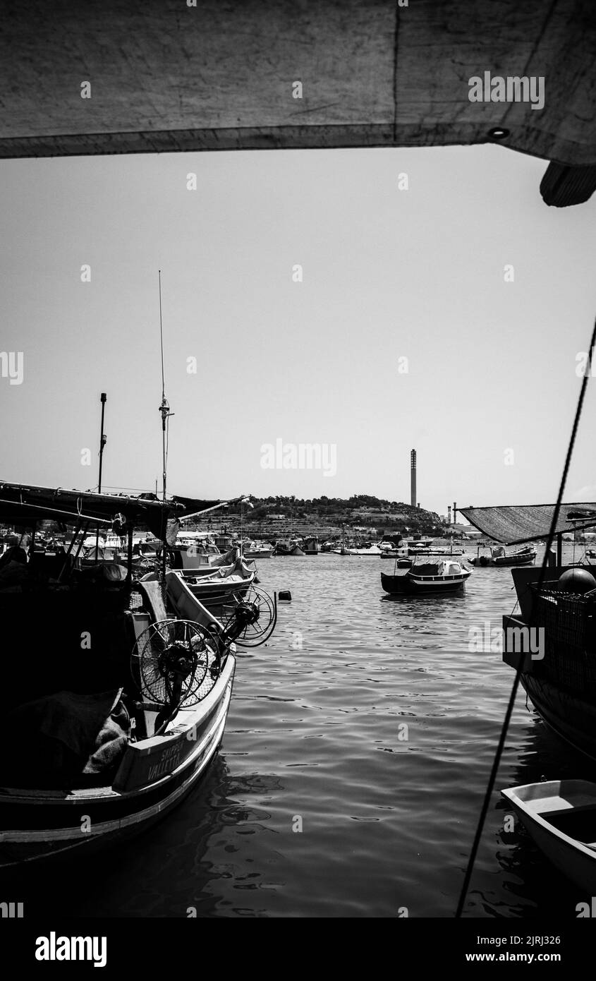 A grayscale shot of boats on a harbor in vertical Stock Photo - Alamy