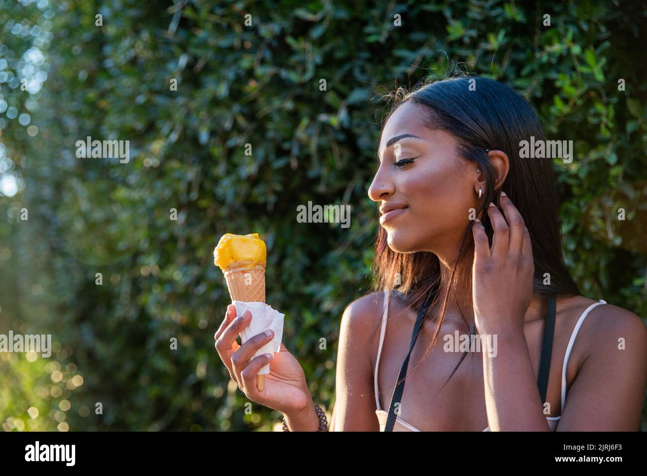 Portrait of an attractive African girl who eats ice cream during sunset Stock Photo
