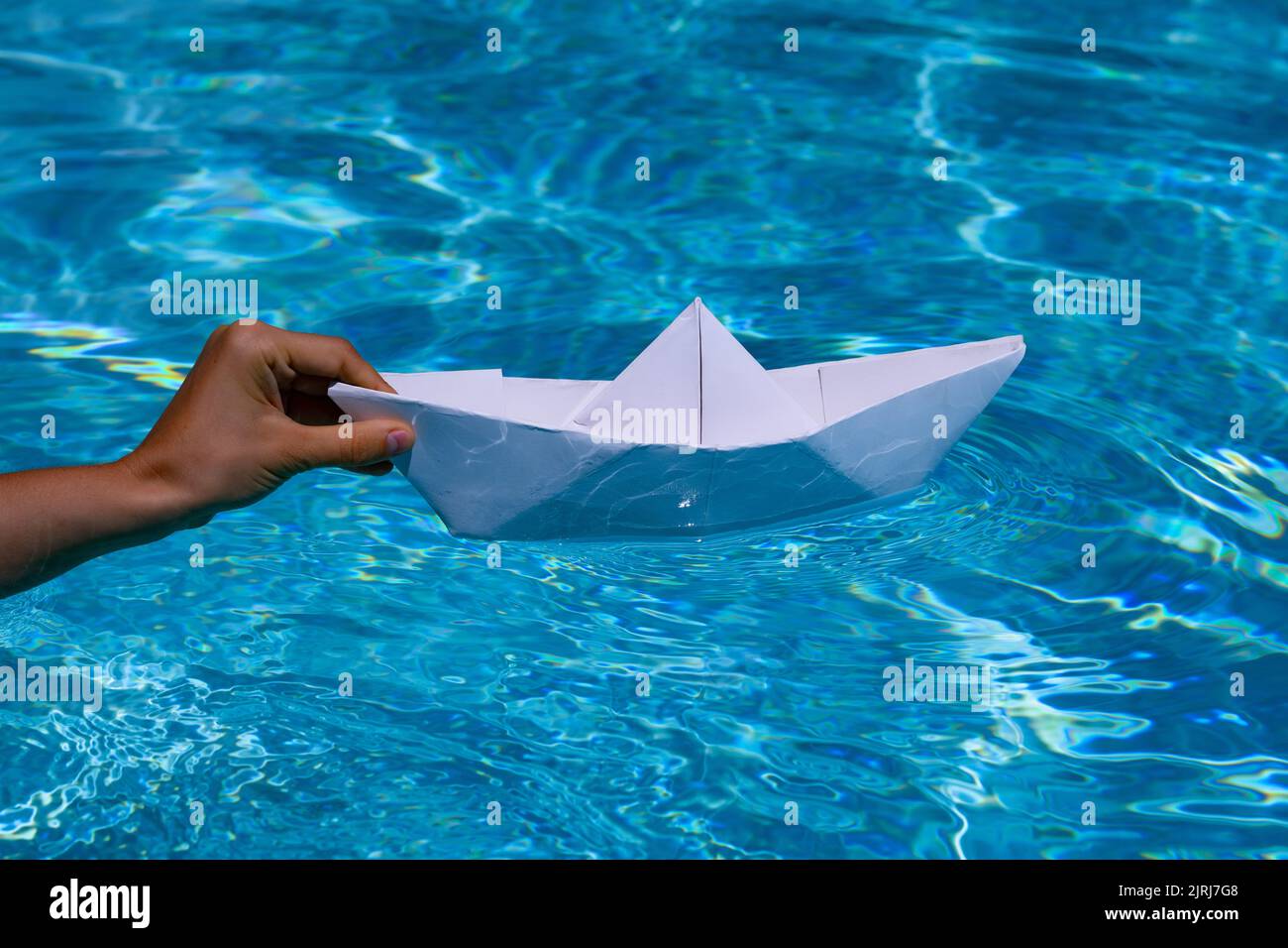 Paper ship in hand. Hand and paper boat. Origami paper boat Stock Photo