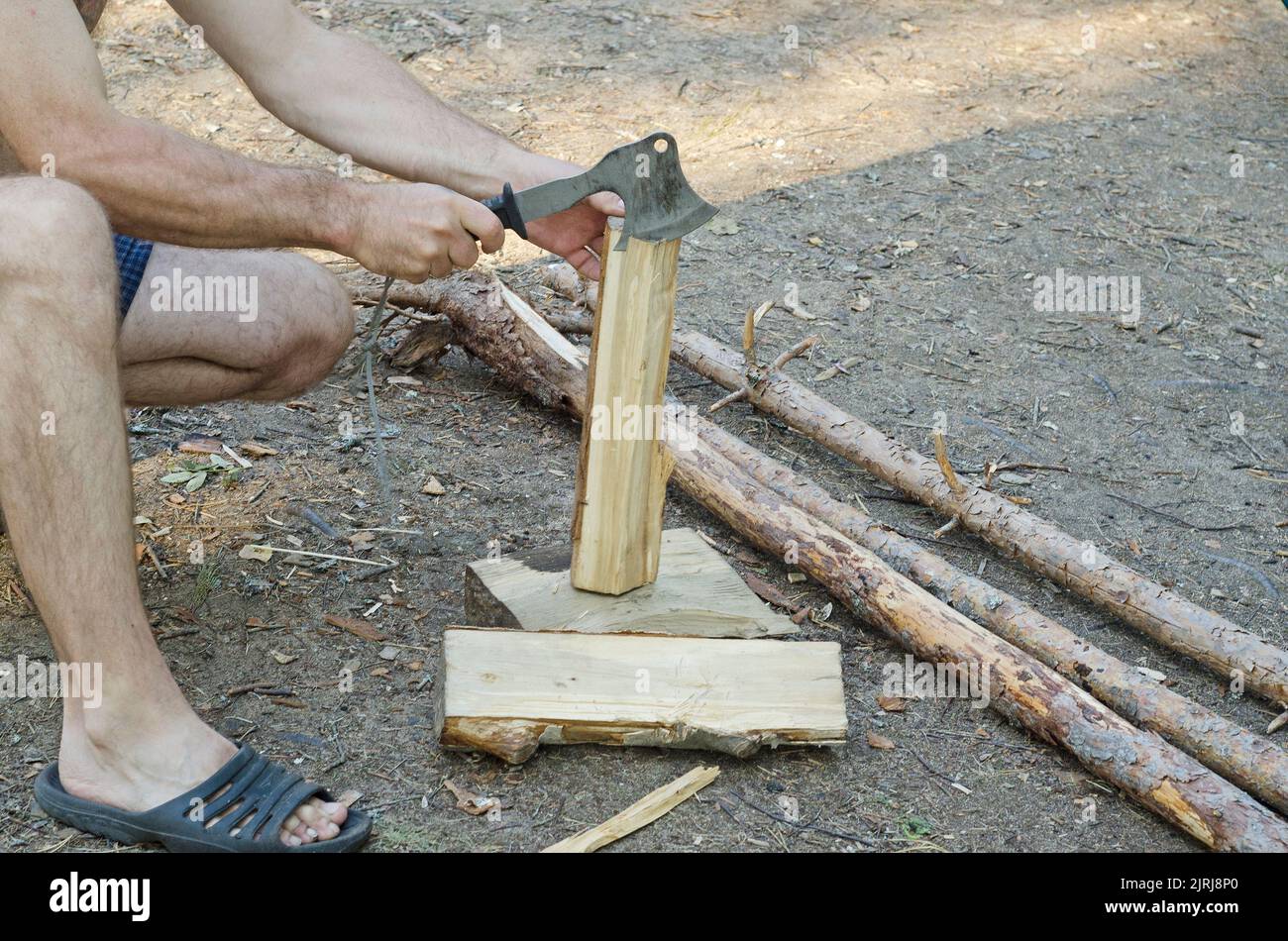 a man chops wood with an axe for heating. Stock Photo