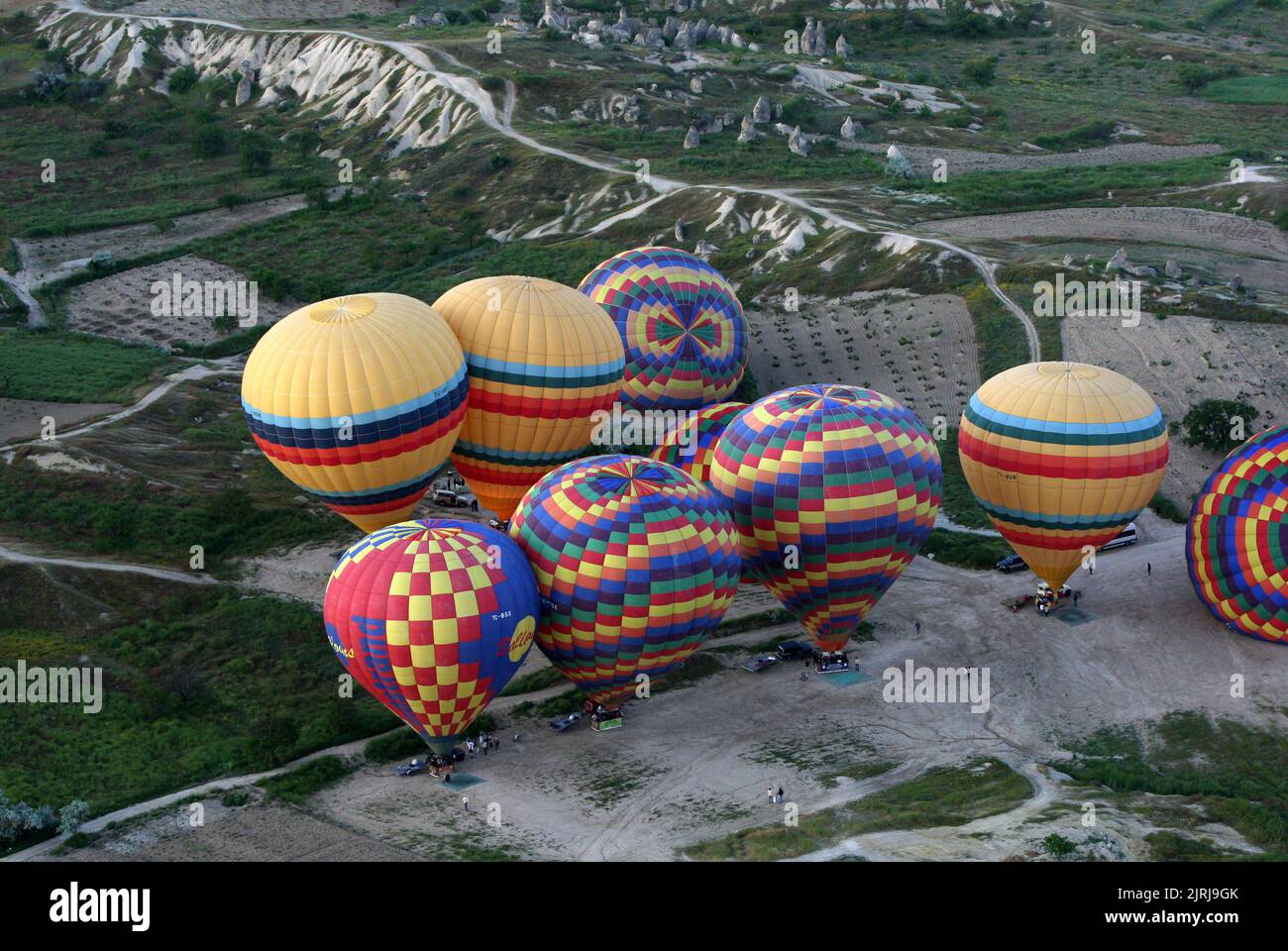 A group of colourful hot air balloons prepare for takeoff at Goreme in the Cappadocia region of Turkey at sunrise. Stock Photo