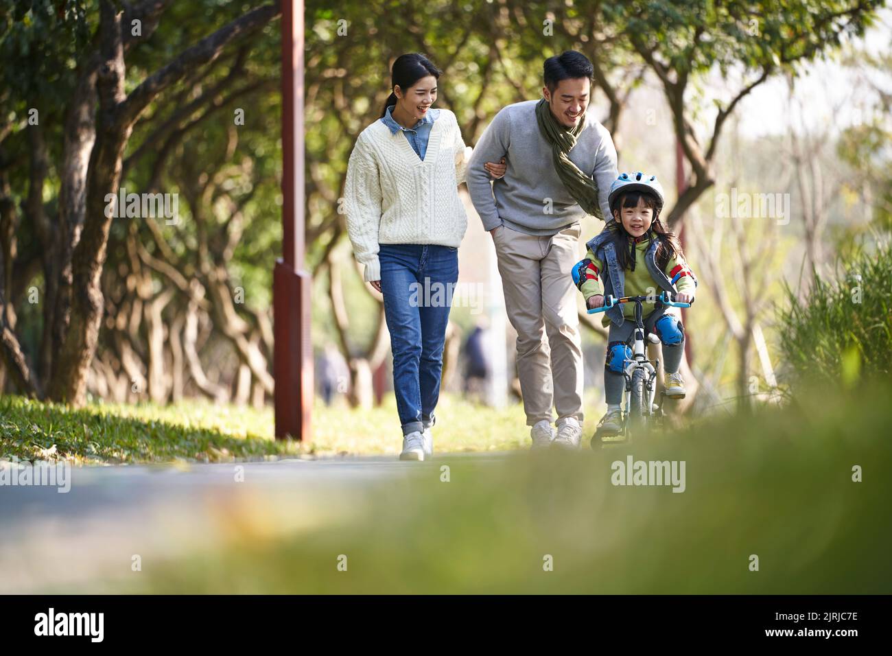 young asian family enjoying outdoor activity in city park Stock Photo