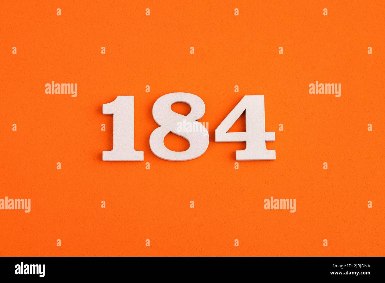 White wooden number 184 on eva rubber orange background Stock Photo - Alamy