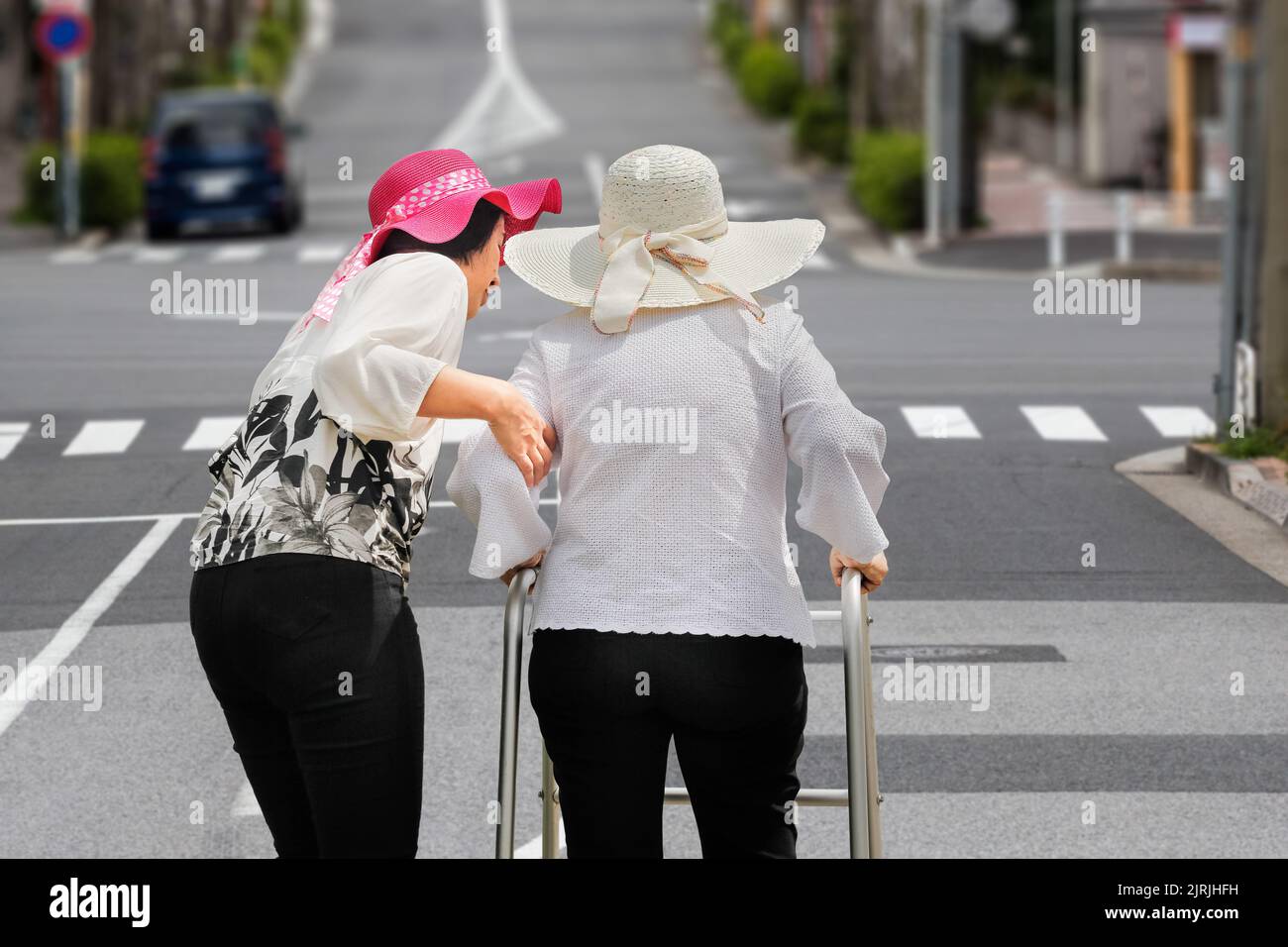Daughter take care elderly woman walking on street in  downtown. Stock Photo
